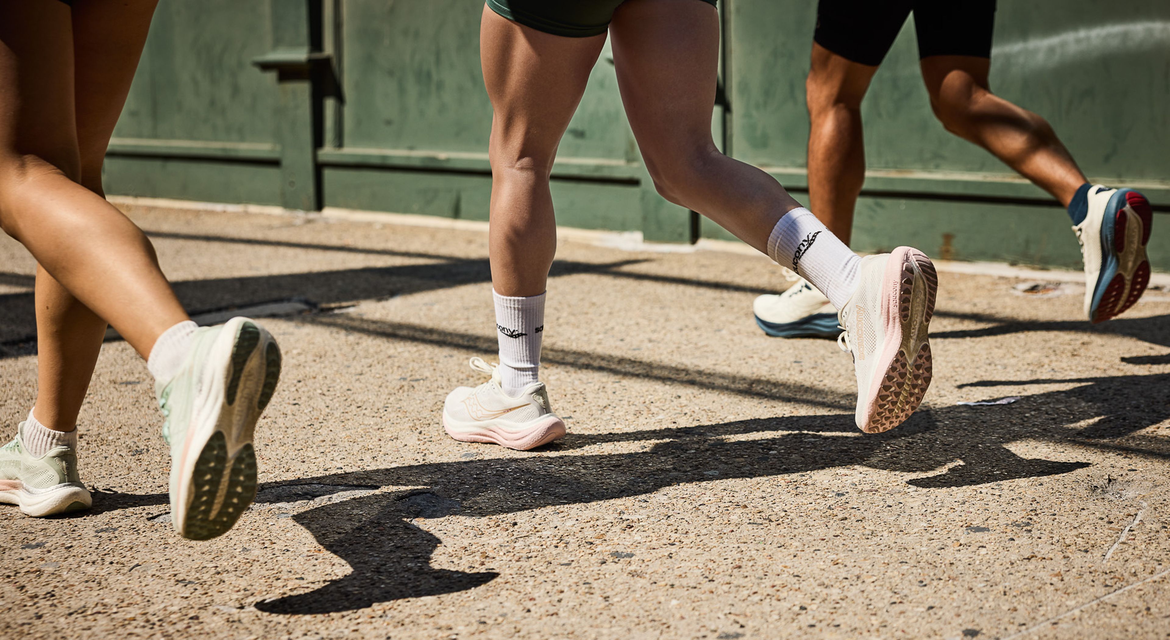 People at a racetrack wearing Saucony shoes